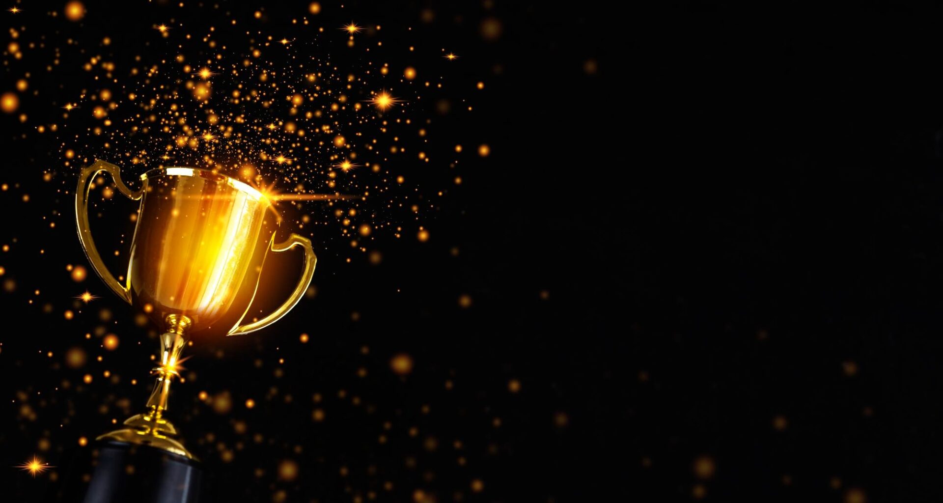 golden trophy with sparkles surronding it on a black background
